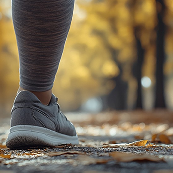 Beine in Sportschuhen bei Spaziergang im Herbstwald, Foto: KI_galam - AdobeStock